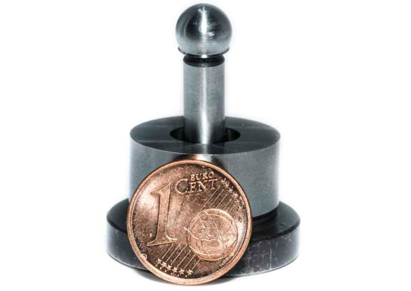 Stift mit Kugelkopf in einer Aufnahme, davor eine 1-Cent-Münze